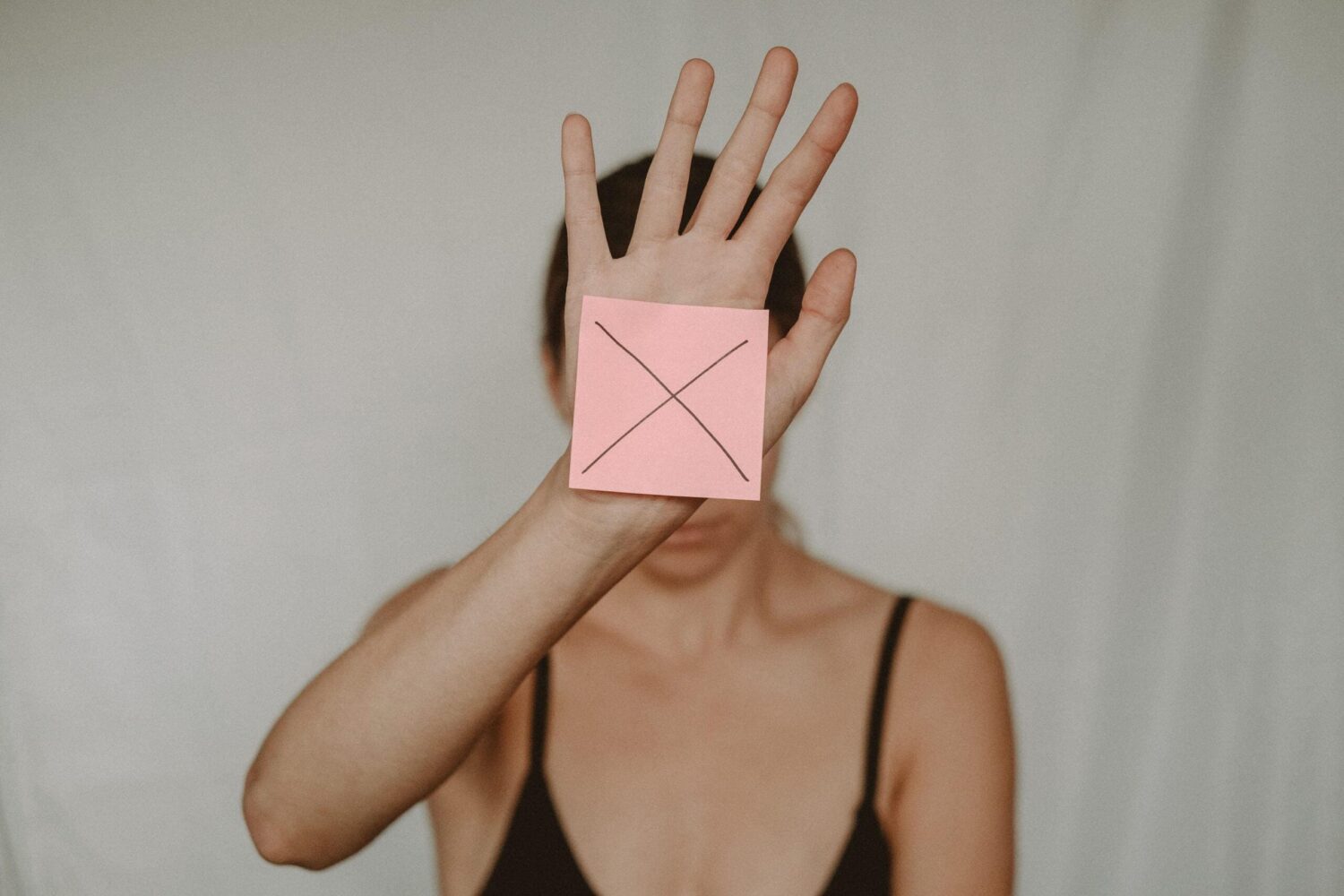 Persoon houdt hand omhoog met symbool voor grens aangeven en nee zeggen in het kader van mentale gezondheid
