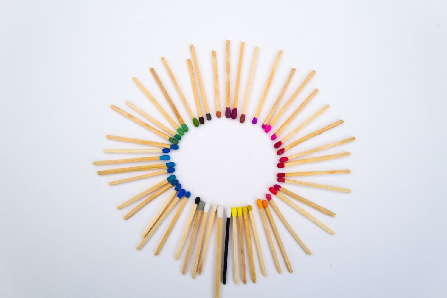 Lucifers in een cirkel gelegd met gekleurde koppen die samen een kleurenspectrum vormen