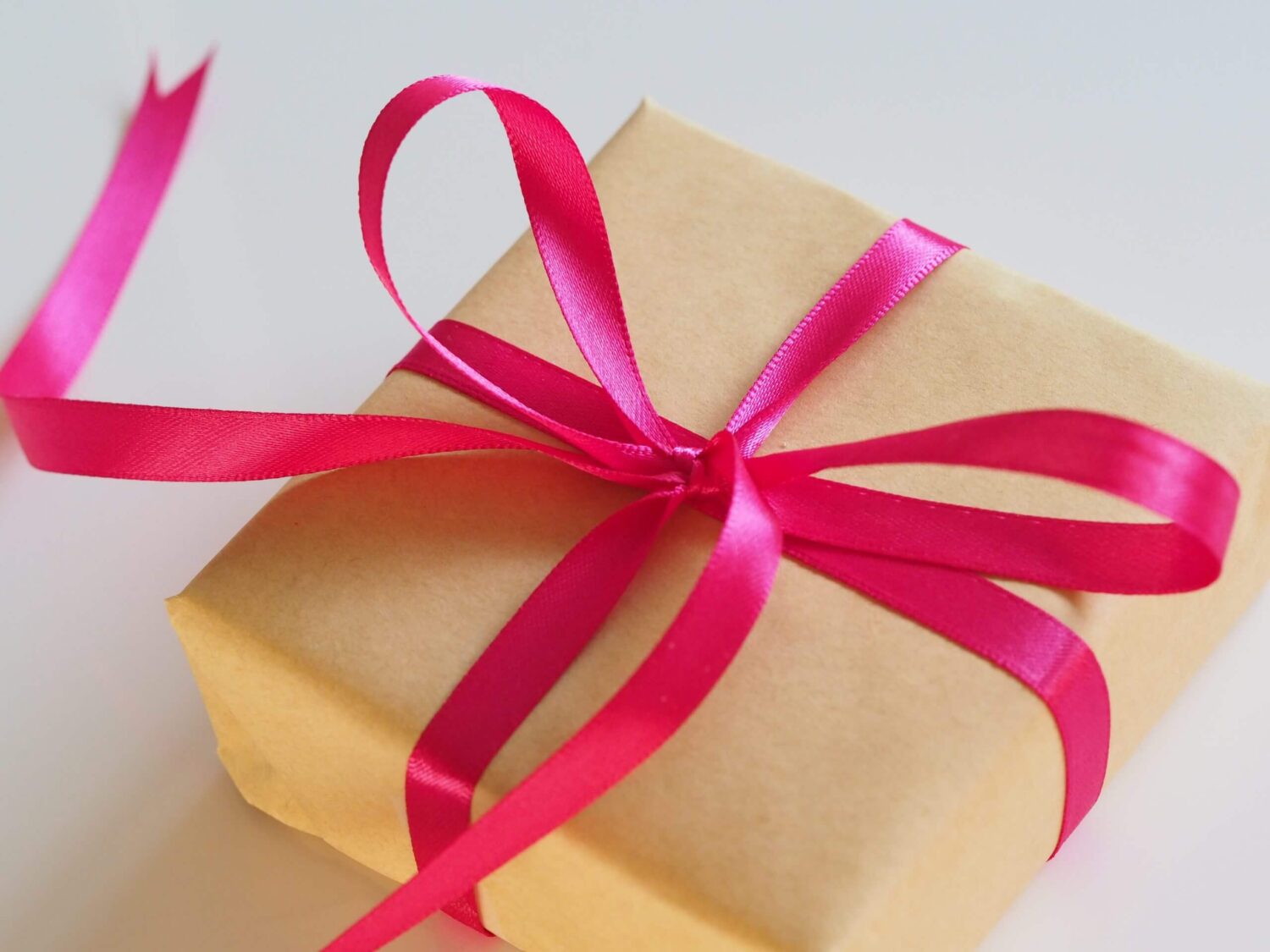 Cadeau verpakt in bruin papier met een roze lint eromheen gestrikt