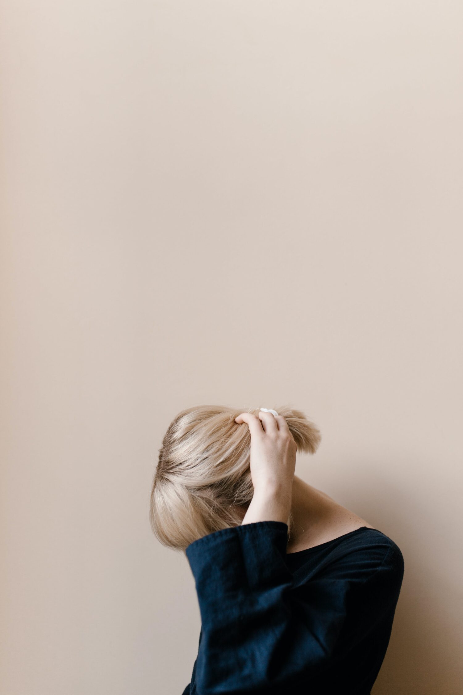 Persoon met hand in het haar, symbool voor stress, overbelasting en mentale klachten