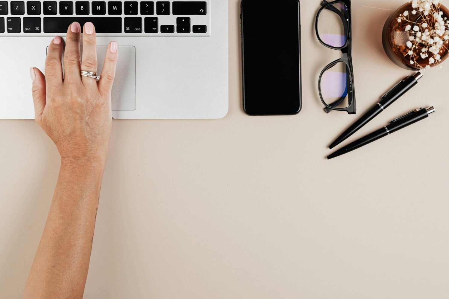 Werkplek met laptop, smartphone en notitiebenodigdheden op een bureau