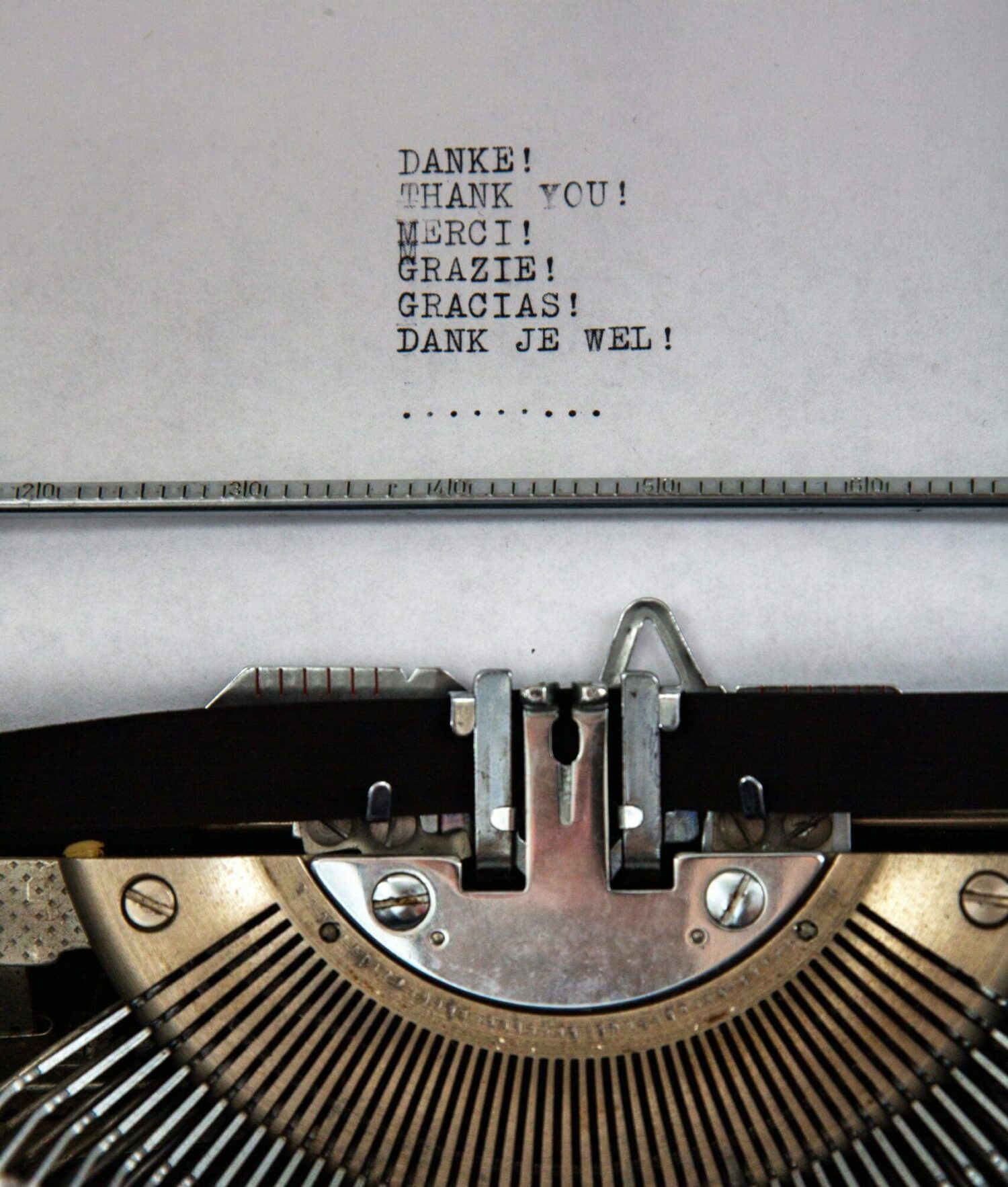 Typemachine met tekst dank je wel in meerdere talen als symbool voor waardering