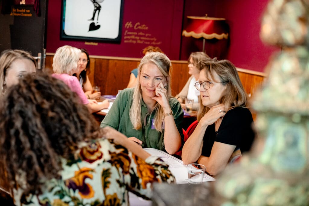 Groep deelnemers in gesprek tijdens interactieve workshop over mentale gezondheid en werkgeluk