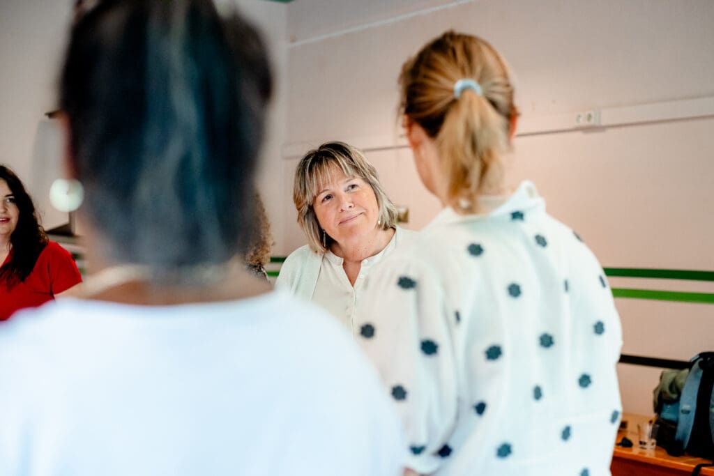 Trainer in gesprek met deelnemer tijdens workshop over mentale gezondheid op de werkvloer