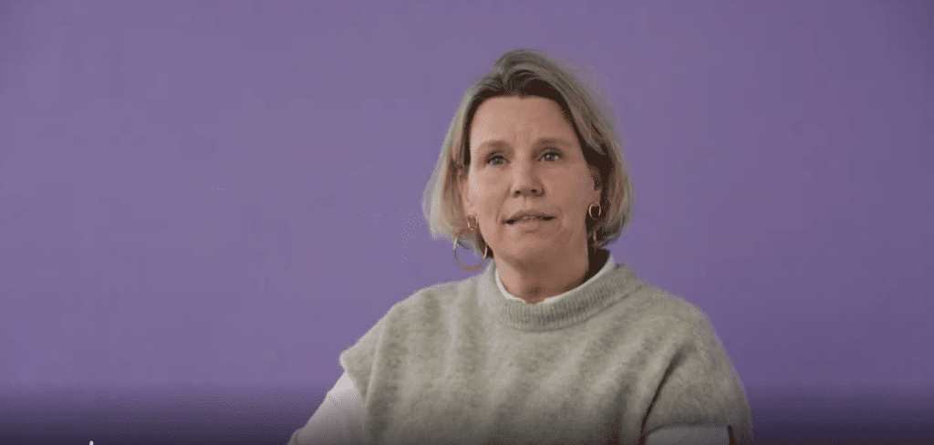 Vrouw met rustige uitstraling tegen paarse achtergrond