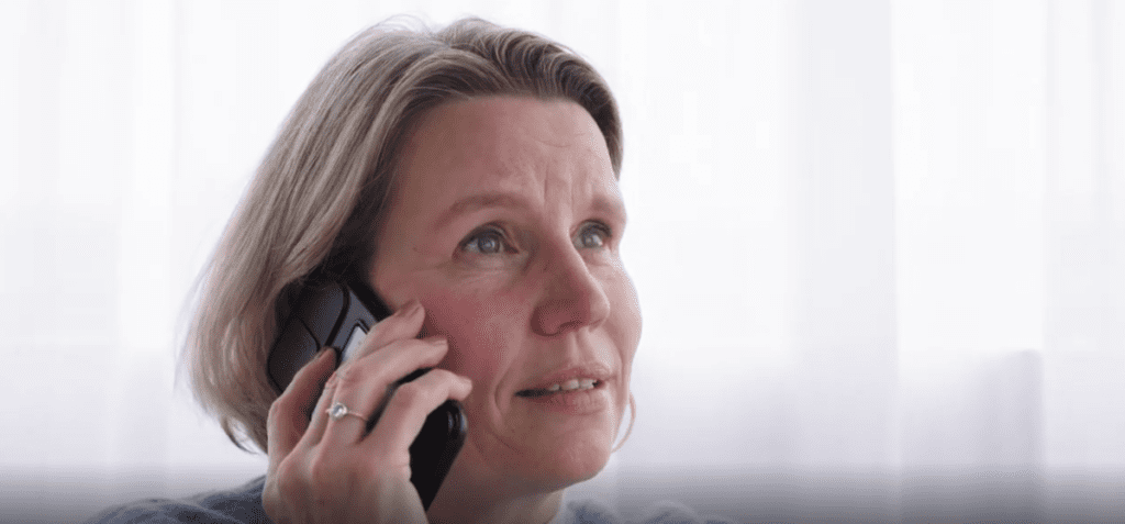 Vrouw in gesprek aan telefoon met rustige en aandachtige uitstraling