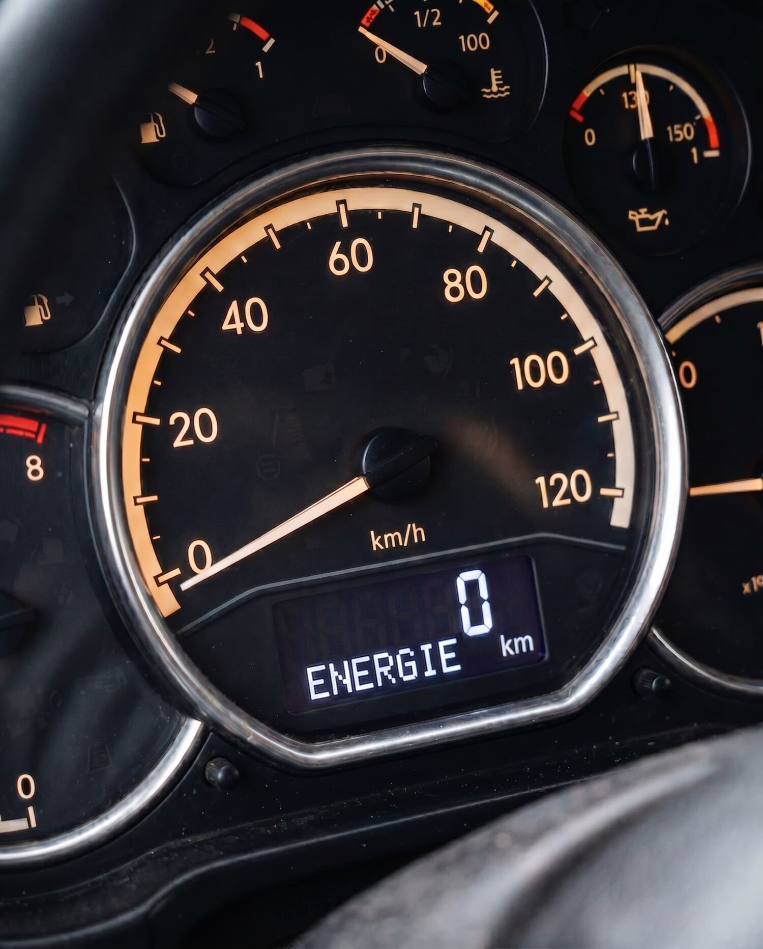 Dashboard van een voertuig met snelheidsmeter en display waarop 'ENERGIE 0 km' staat weergegeven