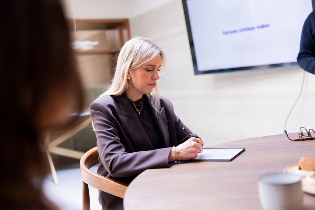 Deelnemer maakt aantekeningen tijdens een teambegeleiding sessie van SpecialistenNet.