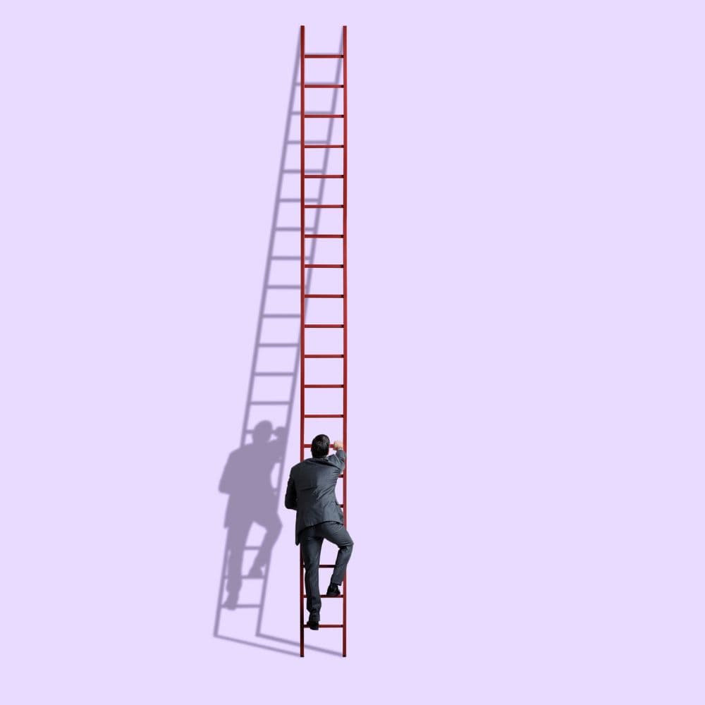 Een man in een donker pak klimt op een hoge, rode ladder tegen een effen lichtpaarse achtergrond. Zijn schaduw valt links op de achtergrond en vormt een tweede silhouet met een ladder. De minimalistische compositie symboliseert ambitie, persoonlijke groei en het bereiken van doelen.
